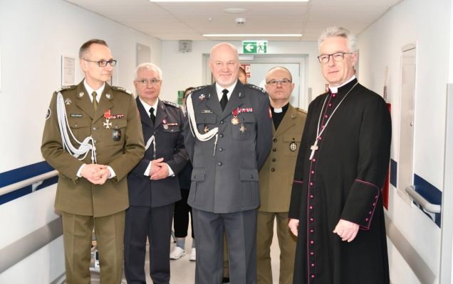 Biskup, dyrektor WIM, Marek Rękas, Jacek Doniec na korytarzu szpitalnym pozują do zdjęcie z biskupem.