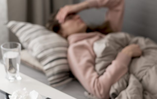 Kobieta leżąca w łóżku chora na grypę.