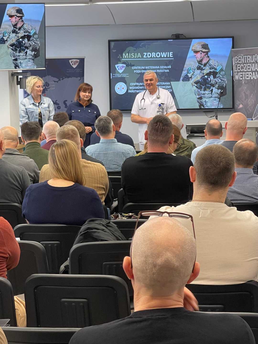 Ujęcie z tyłu sali na słuchaczy i Jarosława Świstaka.