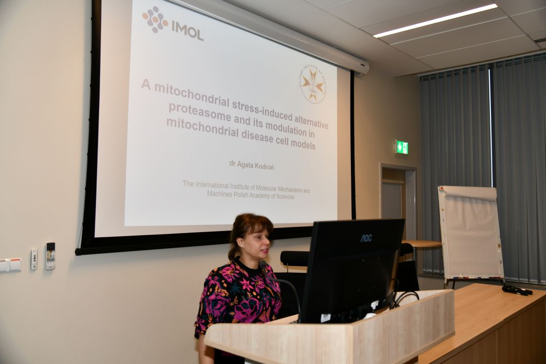 Agata Kodroń przy tablicy z prezentacją prowadzi wykład w sali LOMTI.