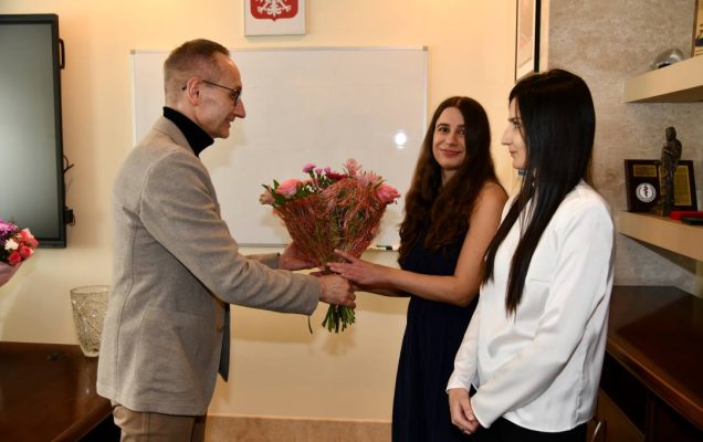 Dyrektor WIM w swoim gabinecie wręcza bukiet kwiatów Dominice Jaskóle-Polkowskiej i Katarzynie Terlikowskiej.