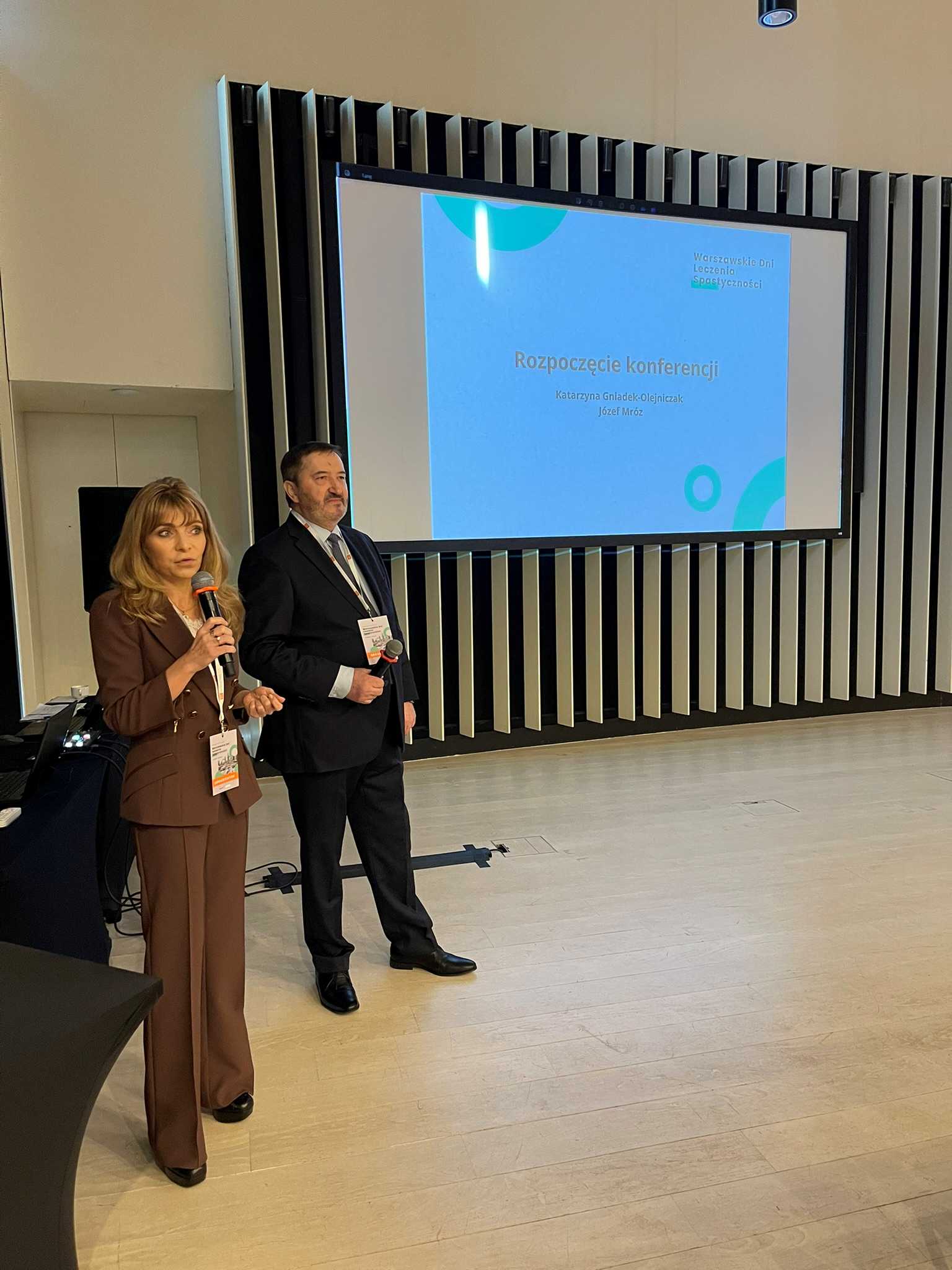 Katarzyna Gniadek-Olejniczak prowadzi prelekcję. Za nią wyświetlacz ze slajdem prezentacji.