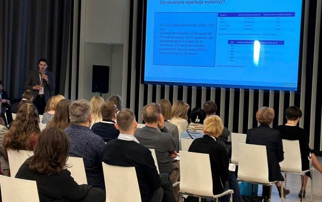 Ujęcie z tyłu sali słuchaczy podczas wykładu na sali konferencyjnej.