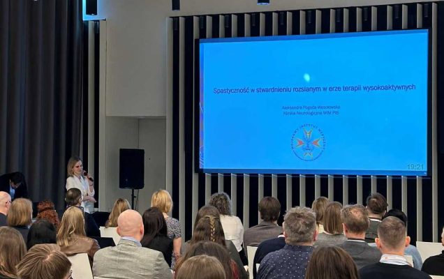 Ujęcie z tyłu sali słuchaczy podczas wykładu na sali konferencyjnej.