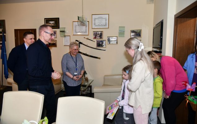 Dzieci wręczają kartki z wielkanocnymi życzeniami dyrekcji WIM.