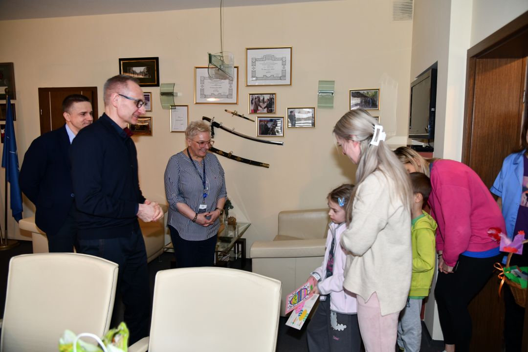 Dzieci wręczają kartki z wielkanocnymi życzeniami dyrekcji WIM.