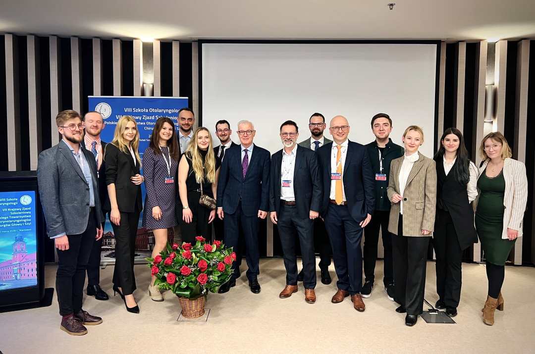 Zdjęcie grupowe prelegentów, przed nimi kosz z bukietem kwiatów.