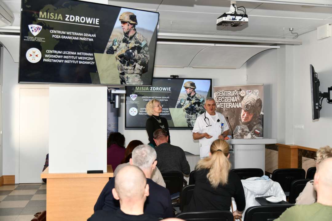 Ujęcie z tyłu sali. Jarosław Świstak i Marta Machunik podczas prelekcji na sali wykładowej.