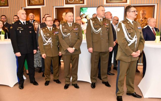 Goście i pracownicy WIM stojący na auli.