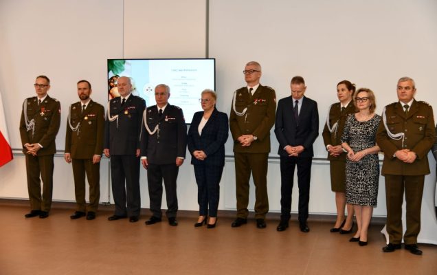 Przedstawiciele dyrekcji WIM stojący na auli podczas uroczystości.