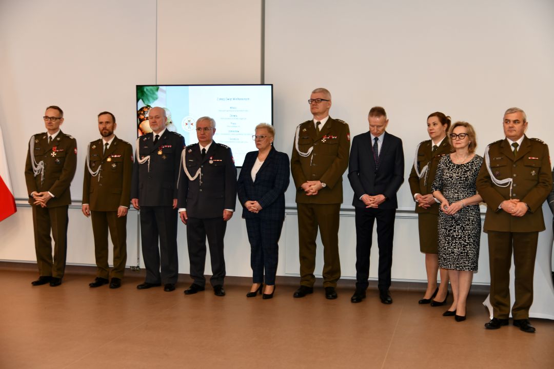 Przedstawiciele dyrekcji WIM stojący na auli podczas uroczystości.