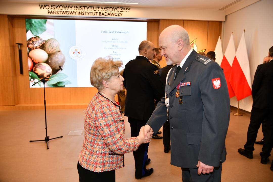 Skłądanie życzeń. Marek Rękas i emerytowana pracowniczka WIM.