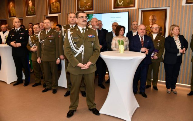 Goście i pracownicy WIM stojący na auli.