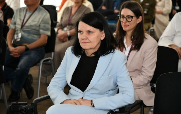 Katarzyna Kacperczyk siedzi na sali podczas uroczystości.