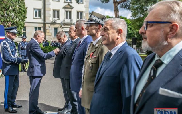 Grzegorz Gielerak w mundurze wojskowym stoi z pozostałymi laureatami w szeregu czekając na wręczenie medalu.