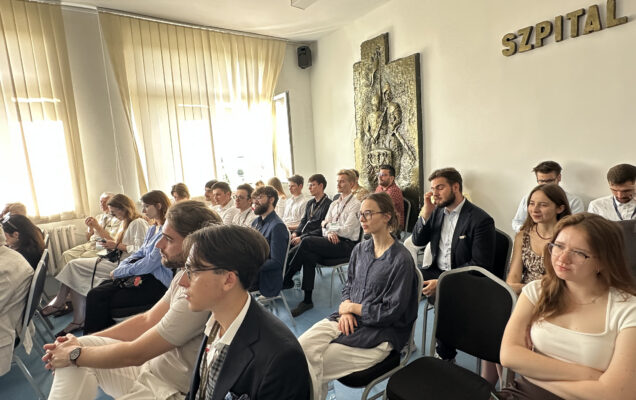Siedzący słuchacze na sali konferencyjnej