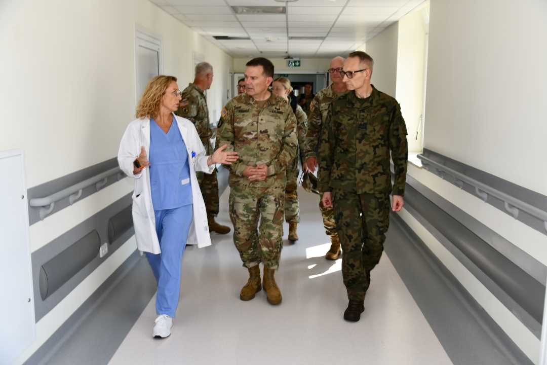 Przedstawiciele US Army razem z Aldoną Chloupek oraz Dyrektorem WIM idą korytarzem i rozmawiają.
