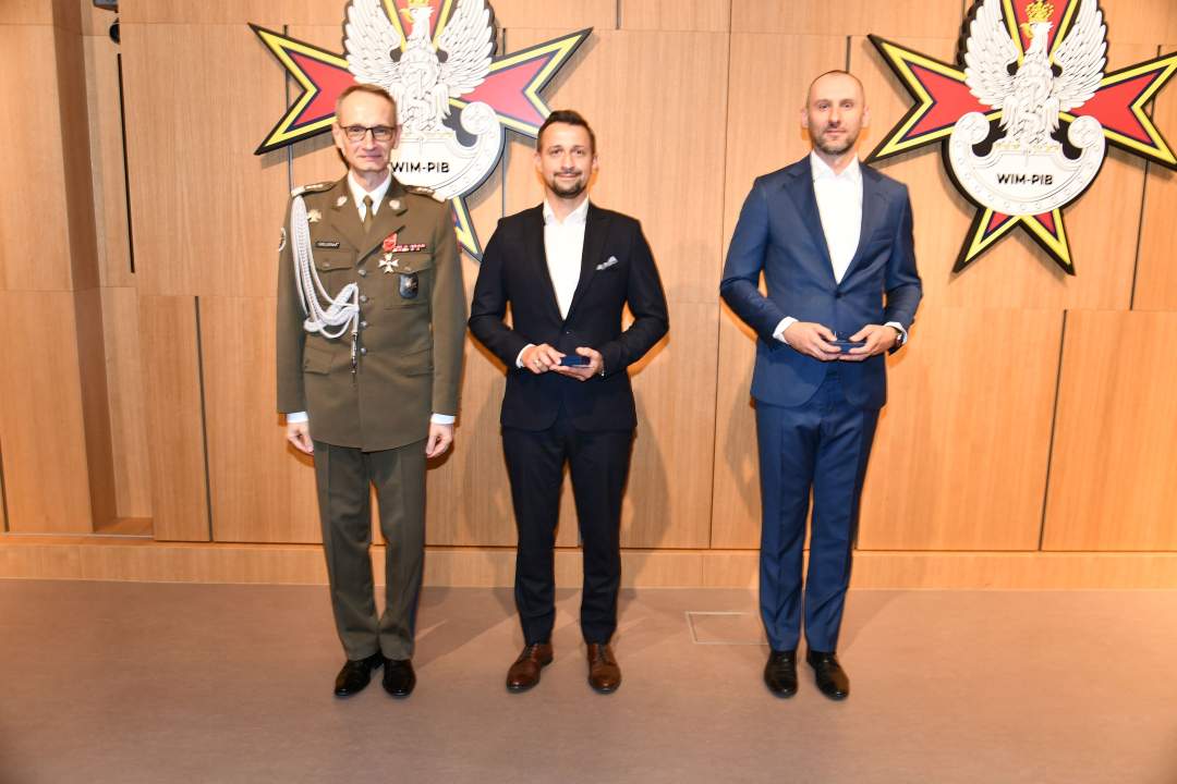 Wyróżnieni pracownicy WIM pozują do zdjęcia z dyrektorem WIM.
