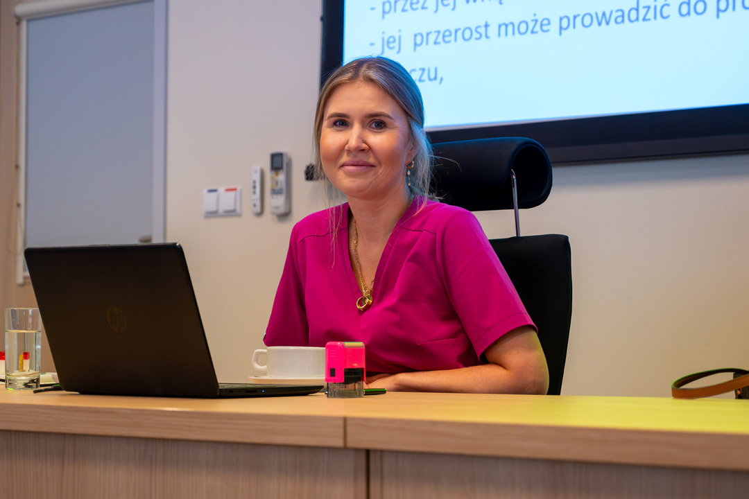 XIII edycja „Misja Zdrowie”, prowadząca prezentację siedzi przy biurku, przed sobą ma laptopa z prezentacją.