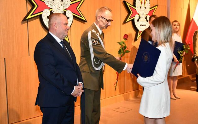 Alojzy Nowak i Grzegorz Gielerak wręczają pracowniczce WIM dyplom.
