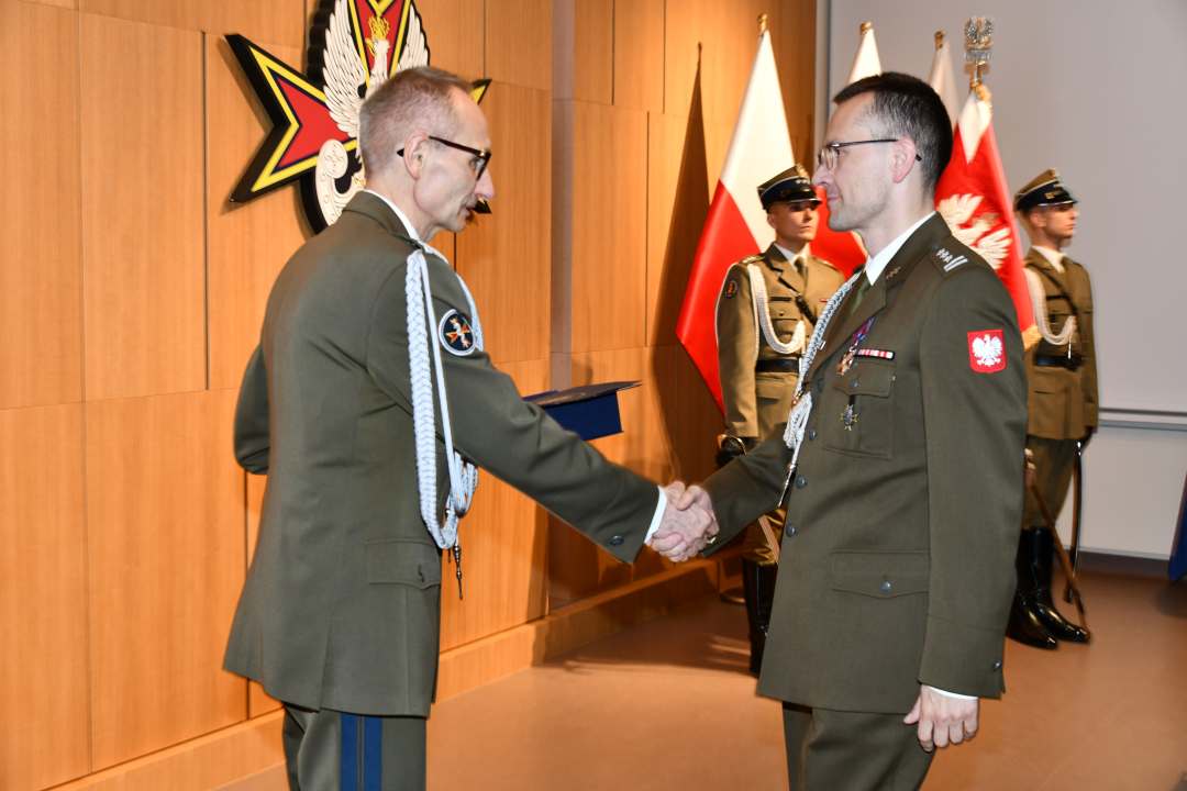 Grzegorz Gielerak wręcza pracownikowi WIM dyplom.