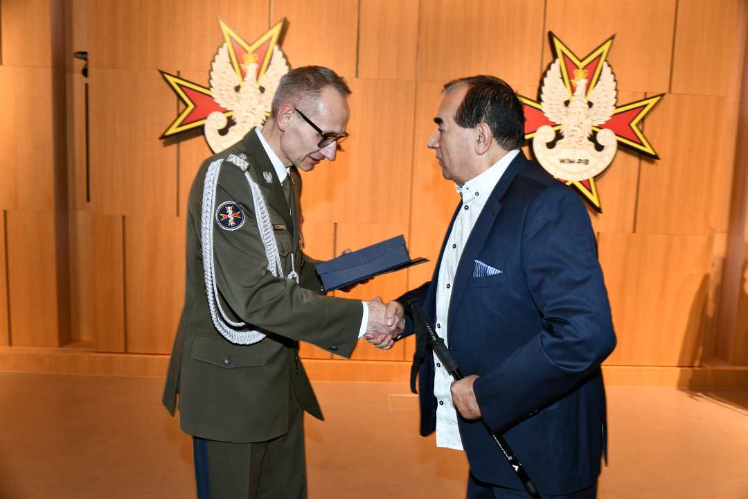 Dyrektor WIM wręcza dyplom laureatowi.