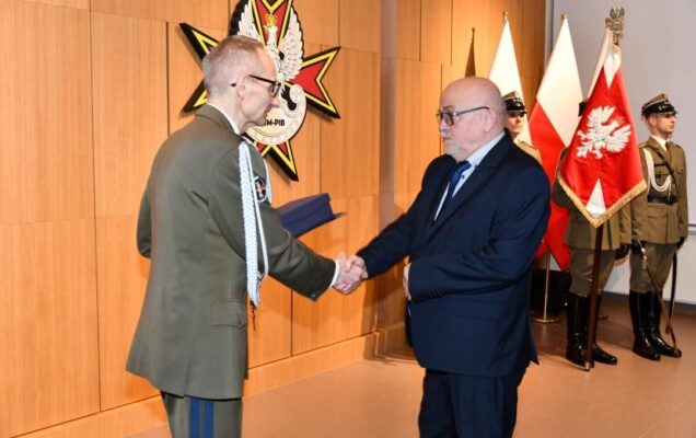Grzegorz Gielerak wręcza pracownikowi WIM dyplom.