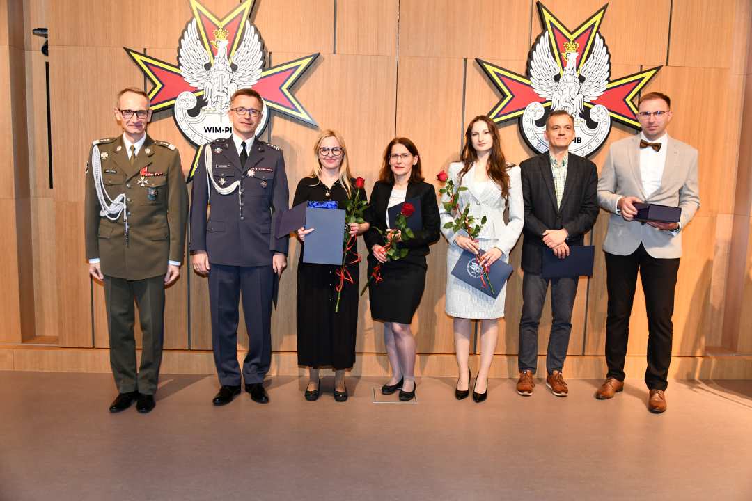 Dyrektor WIM pozuje do zdjęcia z laureatami.