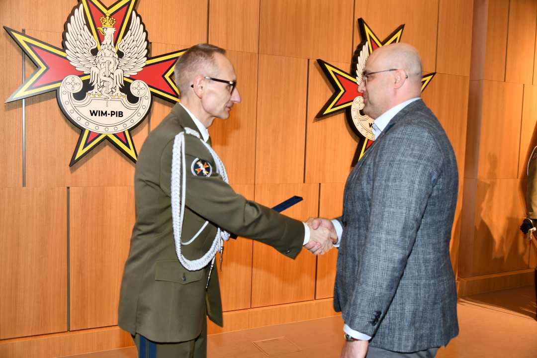Dyrektor WIM wręcza dyplom laureatowi.