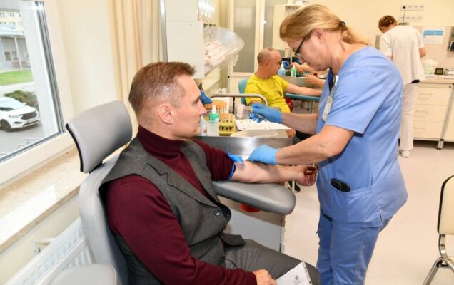 Pielęgniarka pobiera krew weteranowi w gabinecie lekarskim.